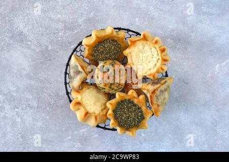 Pasticceria, fatayer o samosa, manaqeesh con zaatar e formaggio bianco su tavola di legno Foto Stock