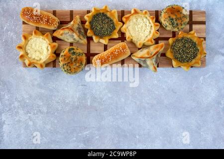 Pasticceria, fatayer o samosa, manaqeesh con zaatar e formaggio bianco su tavola di legno Foto Stock