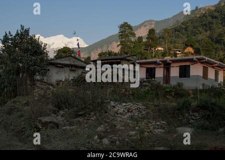 Piccolo villaggio di montagna nepalese durante il tramonto a Ndagi, circuito di Annapurna, Nepal Foto Stock
