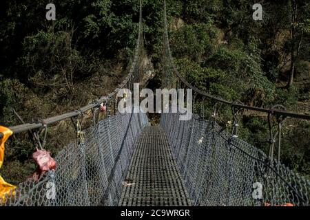 Un semplice ponte sospeso che attraversa il circuito di Annapurna in Nepal Foto Stock