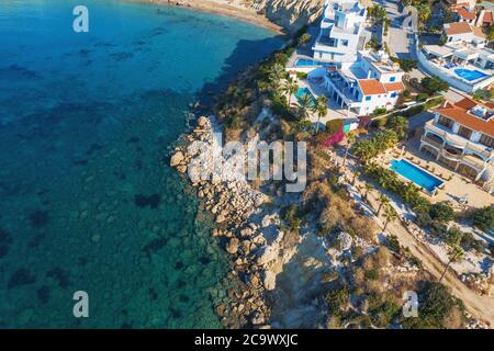 Vista aerea della costa di Cipro con nuovi edifici e ville moderne e il mare blu. Foto Stock