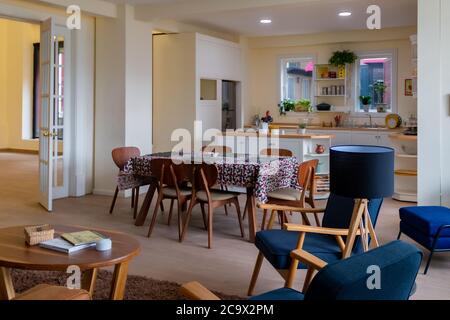 cucina con sala da pranzo fiorita, sedie in legno e accenti blu. Decorazioni moderne Foto Stock