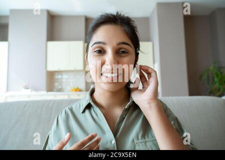 Signora indiana di assistenza clienti operatore indossare cuffie guardare webcam. Colpo di testa Foto Stock