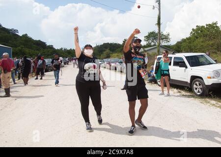 Zinco, Arkansas, Stati Uniti. 2 agosto 2020. 2 agosto 2020: I dimostranti tengono i pugni in aria e gridano a coloro che stanno per strada bloccando l'ingresso al complesso KKK. Una varietà di gruppi tra cui Ozarks Hate Watch e Bridge the Gap NWA stanno marciando su Zinc, AR, in una marcia storica (mai prima Zinc ha avuto una marcia di gruppi neri). Zinco è la casa di Thomas Robb, che è il grandwizard del KKK. Credit: Leslie Spurlock/ZUMA Wire/Alamy Live News Foto Stock