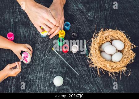 Buona pasqua UNA madre, un padre e un figlio che dipingono le uova di Pasqua. Buona famiglia che si prepara per Pasqua Foto Stock