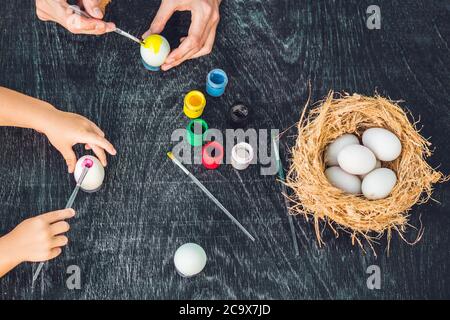 Buona pasqua UNA madre, un padre e un figlio che dipingono le uova di Pasqua. Buona famiglia che si prepara per Pasqua Foto Stock