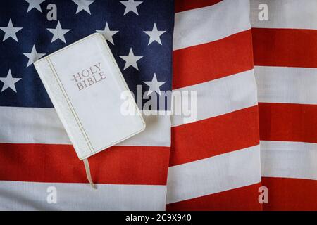 Leggere il libro della Sacra Bibbia con la preghiera per l'america sopra la bandiera americana del ruffle su tavola di legno Foto Stock