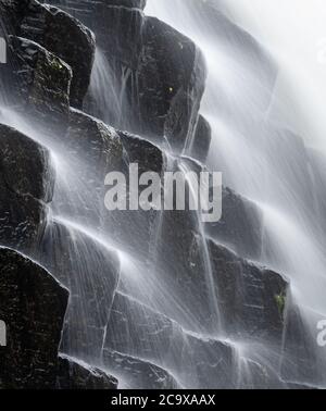 Spruzzi d'acqua nei prismi basaltici Foto Stock