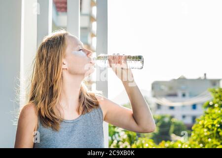 Ritratto di bellezza Donna dai capelli rossi con macchie d'occhio beve acqua. Spa ragazza Foto Stock