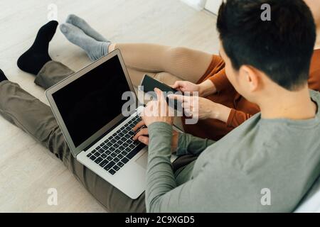Coppia seduta sul letto con computer e smartphone con vista ad alto angolo Foto Stock