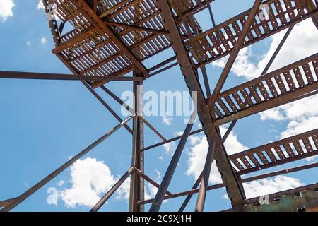 vecchia scala in metallo arrugginito in un cielo blu con nuvole Foto Stock