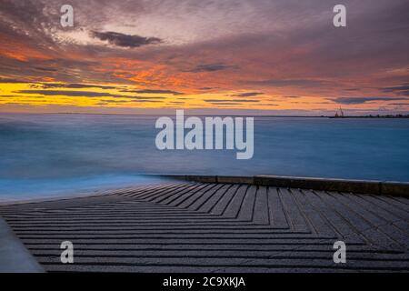 Rampa di barca sulla riva dell'oceano al tramonto - lungo mare di esposizione Foto Stock