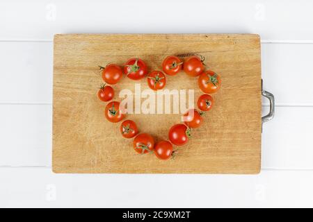 amore cuore composizione di pomodoro su sfondo di legno Foto Stock