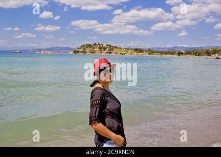 bella giovane donna in un cappello rosso sulla spiaggia Foto Stock