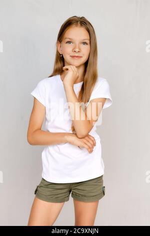 Ritratto di ragazza teenager positiva con la mano vicino al mento Foto Stock