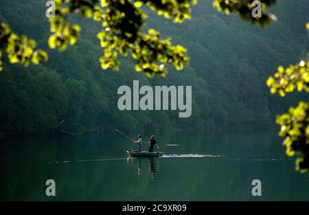 Pescatori in barca sul lago vulcanico Pavin, lago vulcanico, Parco Naturale dei Vulcani d'Alvernia, Puy de Dome, Francia Foto Stock