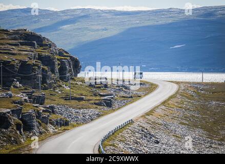 Un caravan di viaggio aka camper van veicolo sulla strada panoramica contea 889 a Havøysund nel nord della Norvegia in estate Foto Stock