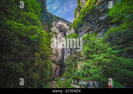 Wulong, Cina - Agosto 2019 : i turisti camminano su un sentiero panoramico che attraversa il paesaggio delle massicce pareti verticali di roccia di Wulong Foto Stock