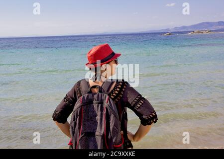 bella giovane donna in un cappello rosso sulla spiaggia Foto Stock