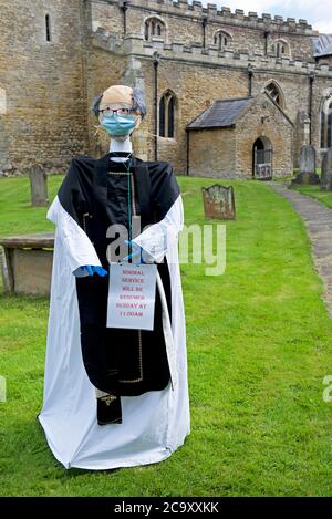 Scarecrow vicar nel cimitero di tutti i Santi Chiesa nel villaggio di North Cave, East Yorkshire, Inghilterra UK Foto Stock