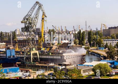 Gdansk, Pomerania / Polonia - 2020/07/14: Vista panoramica sulle infrastrutture industriali del cantiere navale di Danzica vicino all'edificio del Centro europeo di solidarietà Foto Stock