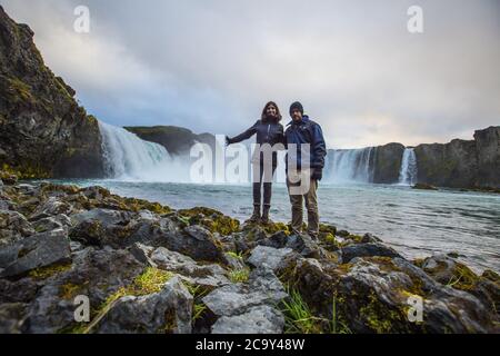 Bella coppia godendo la bella vista della cascata Godafoss in Islanda Foto Stock