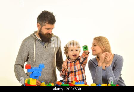 Uomo con barba, donna e ragazzo giocano su sfondo bianco. Concetto di infanzia e di gioco. Genitori e bambini nella sala giochi. La famiglia con i volti eccitati si costruisce a. Foto Stock