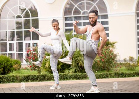 Nell'accogliente cortile posteriore del famoso centro fitness studenti e sportivi ballano e karate gruppo facendo shot spettacolo-spettacolo. Foto Stock