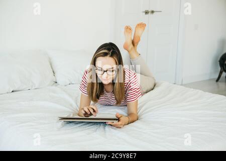 L'artista digitale ragazza disegna con uno stilo su un tablet o un computer portatile. È una studentessa e sta studiando disegno o è questa la sua professione professionale. Foto Stock