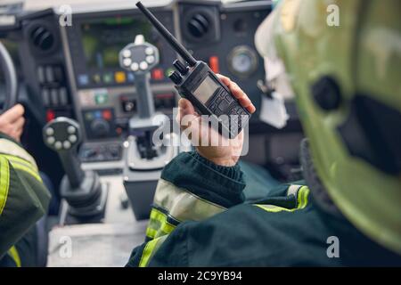 Pompiere che tiene walkie talkie alla macchina antincendio Foto Stock