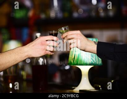 Le mani maschili si rallegrano con l'alcol su sfondo sfuocato della barra. Concetto di bevanda alcolica. Amici bere shot o liquore e Grazie. Le mani maschili si rallegrano con bicchieri di pallino o liquore o liquido alcolico. Foto Stock