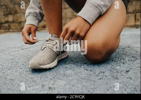 Ragazza giovane attraente che corre intorno nei vestiti di idoneità in una giornata piovosa Foto Stock