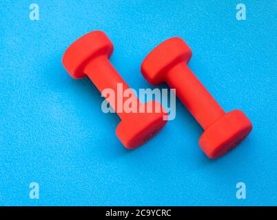 Due pesi rossi sullo sfondo blu Foto Stock