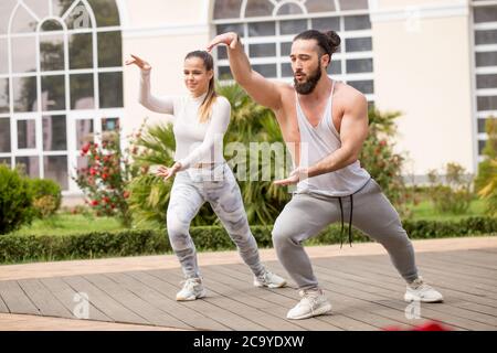 Nell'accogliente cortile posteriore del famoso centro fitness studenti e sportivi ballano e karate gruppo facendo shot spettacolo-spettacolo. Foto Stock