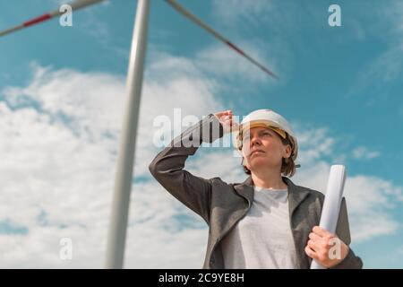 Ritratto di ingegnere femminile in una moderna azienda agricola di turbine eoliche durante la pianificazione del progetto di manutenzione Foto Stock