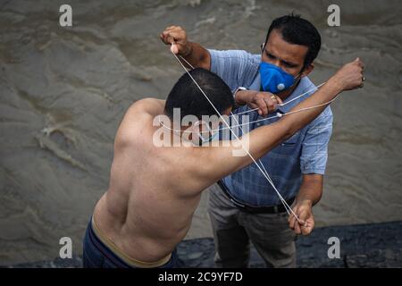 Kathmandu, Nepal. 3 agosto 2020. I devoti eseguono rituali durante il festival. Durante Janai Purnima, conosciuto anche come il festival del Sacro filo o il festival di Rakshya Bandhan, gli uomini indù, specialmente i Brahmans e Chettris, eseguono il loro cambio annuale di Janai, fili sacri indossati sul petto o legati intorno al polso. Credit: SOPA Images Limited/Alamy Live News Foto Stock