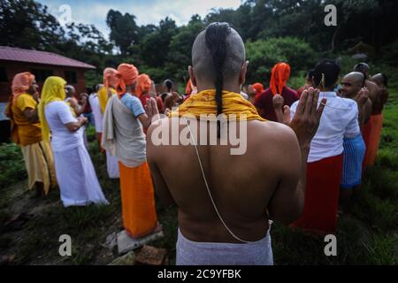 Kathmandu, Nepal. 3 agosto 2020. I devoti eseguono rituali durante il festival al tempio di Pashupatinath. Durante Janai Purnima, noto anche come festival del Sacro filo o festival di Rakshya Bandhan, gli uomini indù, specialmente i Brahmans e Chettris, eseguono il loro cambio annuale di Janai, fili sacri indossati sul petto o legati intorno al polso. Credit: SOPA Images Limited/Alamy Live News Foto Stock