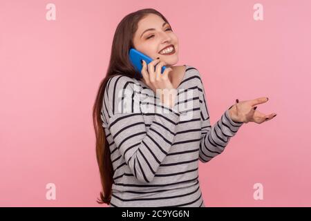Comunicazione mobile. Ritratto di allegra donna felice in felpa a righe sorridente felice mentre parla su cellulare e gesturing, dicendo bene n Foto Stock