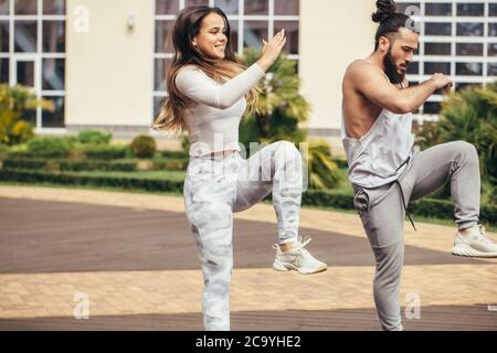 Nell'accogliente cortile posteriore del famoso centro fitness studenti e sportivi ballano e karate gruppo facendo shot spettacolo-spettacolo. Foto Stock