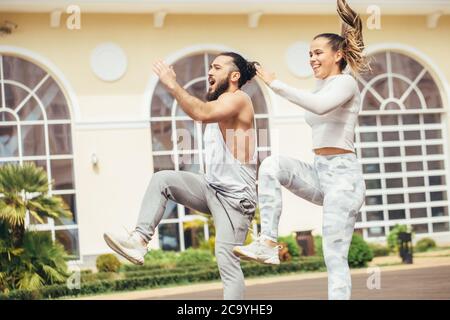 Nell'accogliente cortile posteriore del famoso centro fitness studenti e sportivi ballano e karate gruppo facendo shot spettacolo-spettacolo. Foto Stock