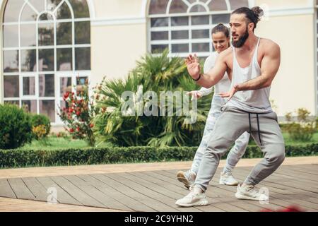 Nell'accogliente cortile posteriore del famoso centro fitness studenti e sportivi ballano e karate gruppo facendo shot spettacolo-spettacolo. Foto Stock