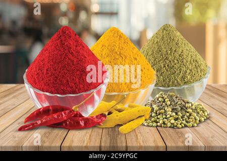 Curcuma, peperoncino, coriandolo, Aldi in polvere, Marcha, Dhana, semi di coriandolo, peperoncino secco, radice curcuma, masala in ciotola, legno & sfondo bianco - immagine Foto Stock