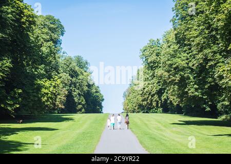 La famiglia cammina insieme al Cirencester Park in estate Foto Stock