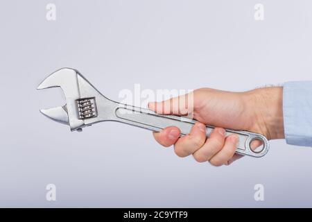 Chiave di bloccaggio manuale maschio su fondo bianco. Chiave meccanica in mano. Vista laterale. Foto Stock