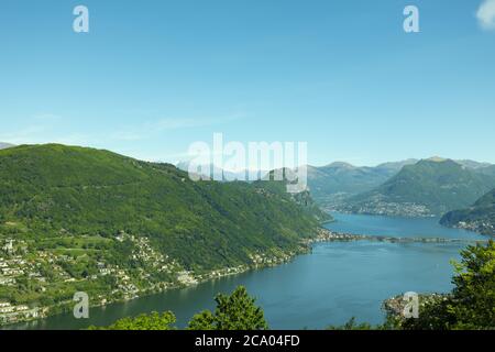 Aerail Vista su Lugano con Lago Alpino e montagna in una giornata di sole in Ticino, Svizzera. Foto Stock