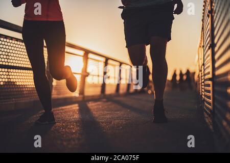 Corpo parte sagome di coppia che è jogging in città al tramonto. Foto Stock