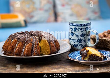 Deliziosa torta di Pasqua, cestino di noci e cacao caldo su vecchio tavolo di legno scuro - bel pomeriggio durante il soggiorno a casa. Foto Stock