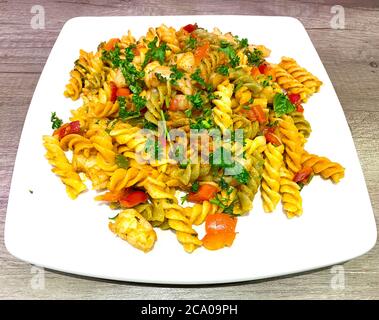 Burro all'aglio e gamberi di prezzemolo saltati e aggiunti alla pasta di tinta fusilli con un pesto di peperoncino ardente Foto Stock