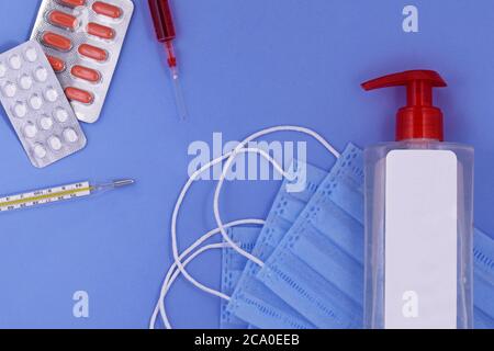 Maschera medica protettiva, pillole, termometro, siringa, disinfettante per le mani, protezione da virus corona, concetto di prevenzione e trattamento coronavirus, covid Foto Stock