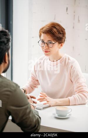 I partner aziendali discutono dei dettagli prima di firmare il contratto al computer Foto Stock